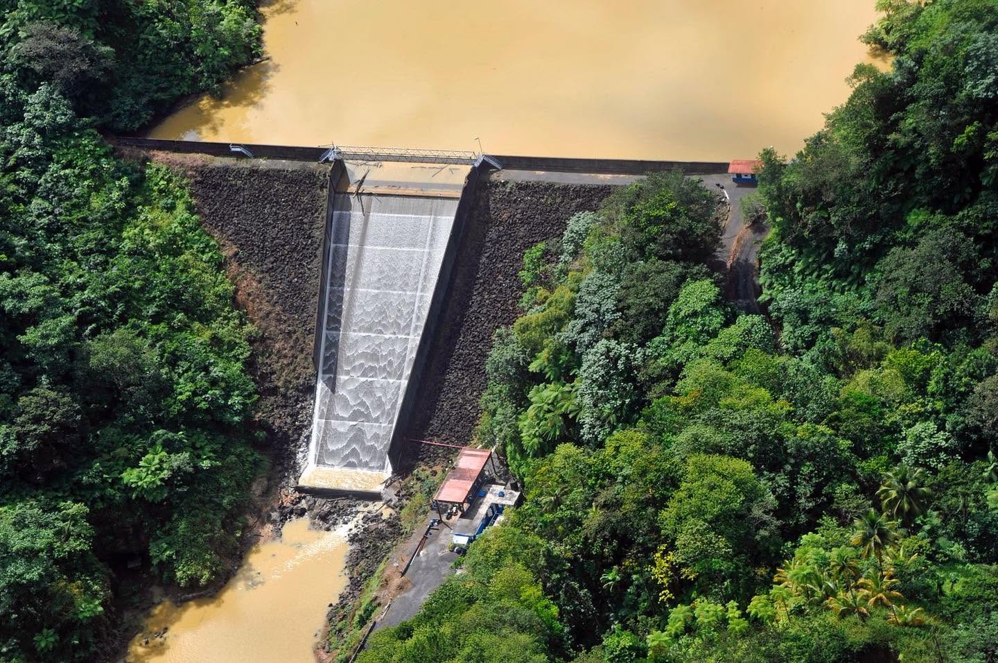 Aerial view of John Compton Dam and its forested surroundings